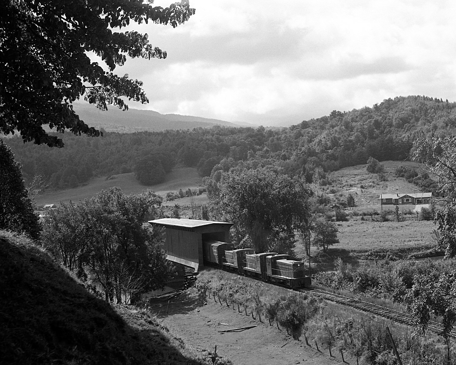 St. Johnsbury & Lamoille County Railroad train with 70 tonners Montpelier & Barre #19, StJ&LC #54 and #46 pass through the covered bridge at Cambridge Juncion, Vermont. Mid to late 1960's. (8x10) St. Johnsbury & Lamoille County Railroad train with 70 tonners Montpelier & Barre #19, StJ&LC #54 and #46 pass through the covered bridge at Cambridge Juncion, Vermont. Mid to late 1960's. (8x10)